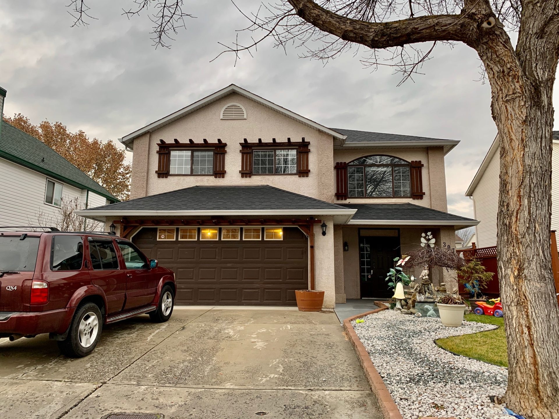 Decorative Photo Of House Along With Car and private parking on a cloudy day in Kelowna.