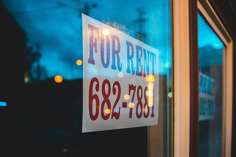 A FOR RENT sign with a contact phone number