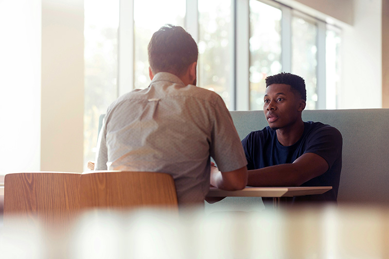 Two people sitting down at a table discussing a rental agreement. Definitely not a stock image.