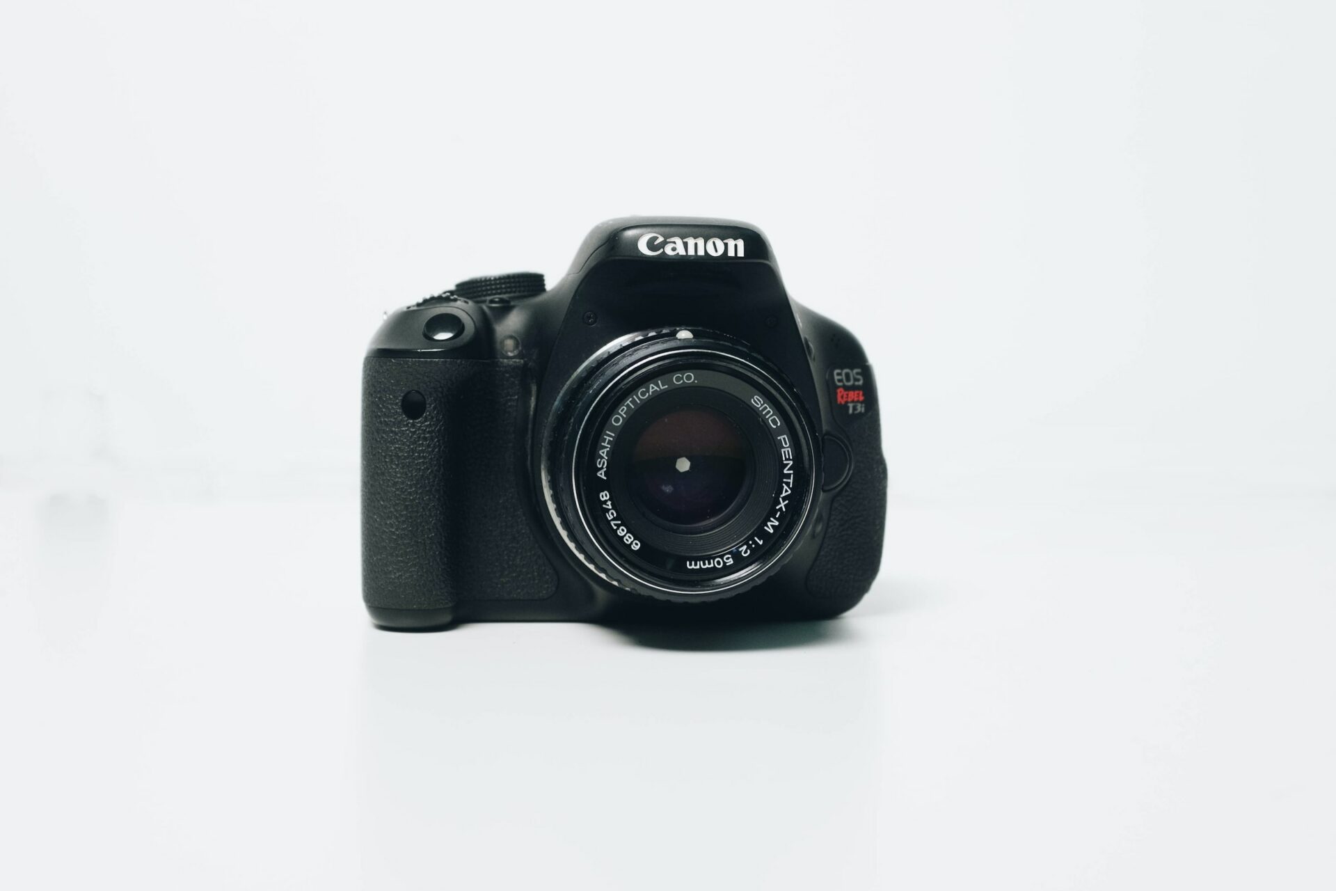 A black Canon professional camera sitting on a white background, perfect for professional photography.