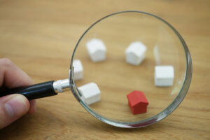 Looking at toy houses through a magnifying glass