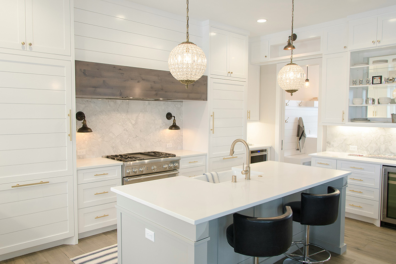 Modern kitchen with quartz counters, backsplash, pendant lights, and new appliances.